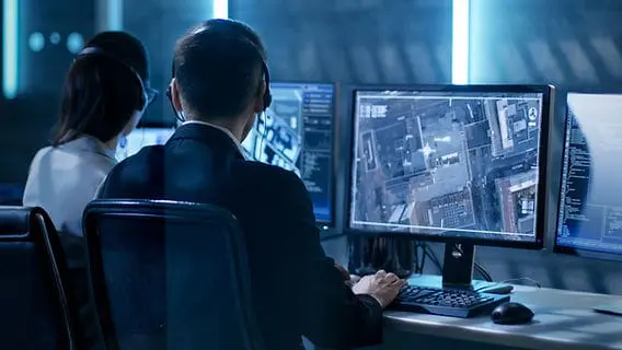Security professionals monitoring building surveillance systems from a control room in Seattle