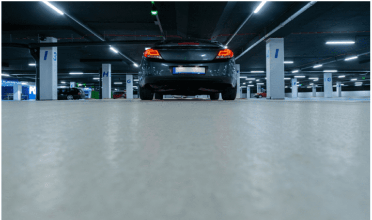 Modern parking garage with surveillance cameras monitoring vehicles for enhanced building security in Northern California ا
