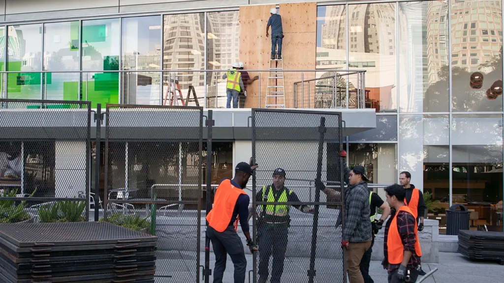 Construction workers installing temporary security fencing to protect a construction site in Northern California.